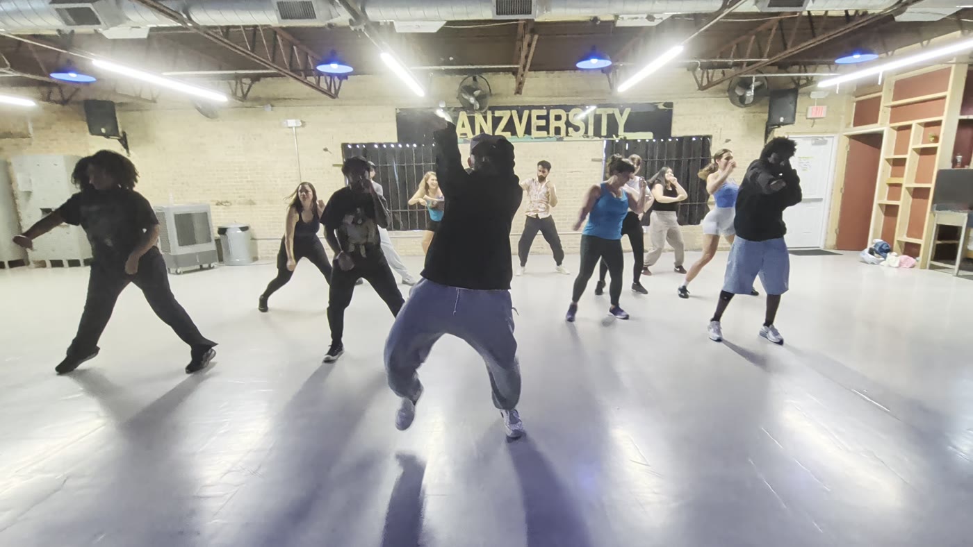 Adults mid-groove in a (Found)ations class under the Danzversity sign