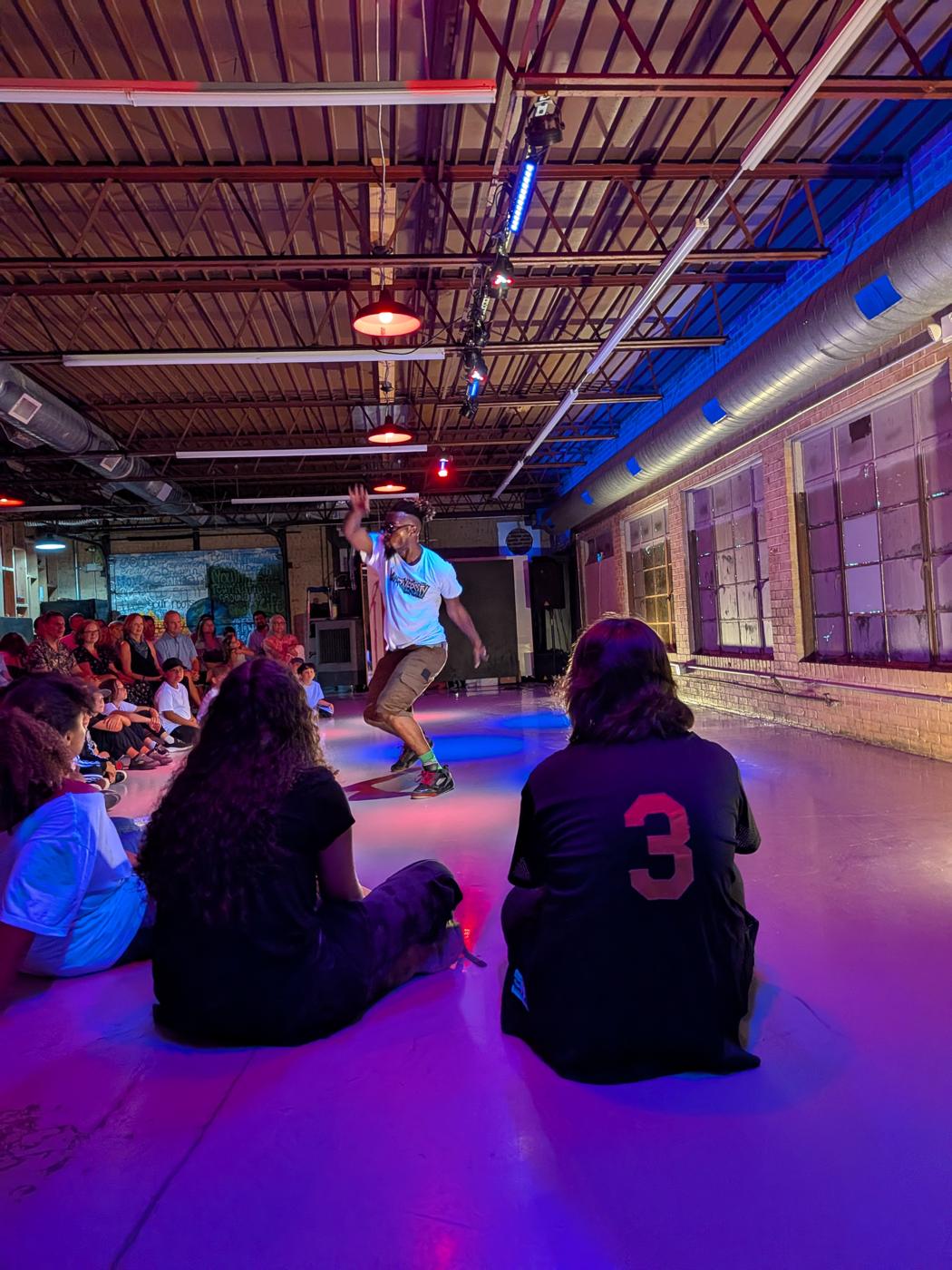 View from the audience circle as a student dances in the middle