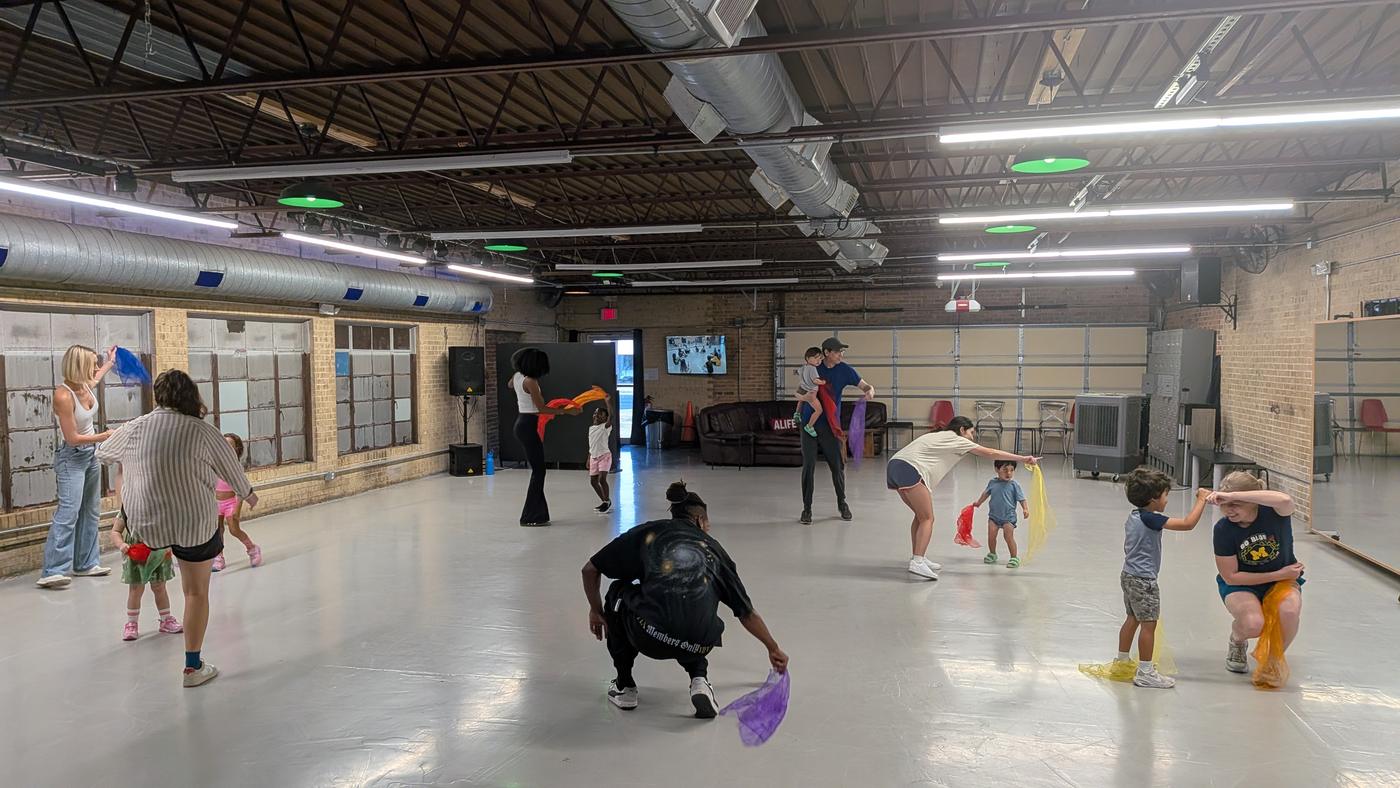 Toddlers and their grown-ups dancing with scarves in a Root Runners class at Danzversity in Austin